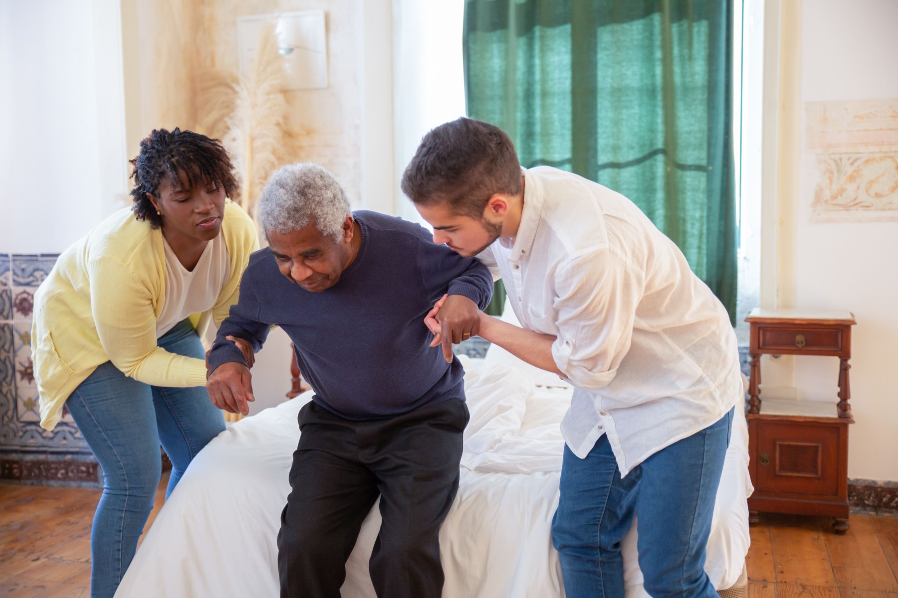 Caregivers helping an older person stand safely